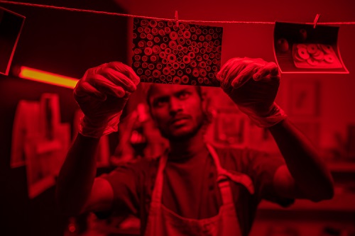 Man processing photos in dark room