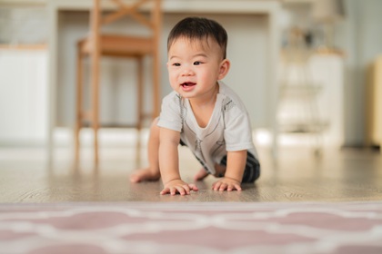Baby crawling on floor.